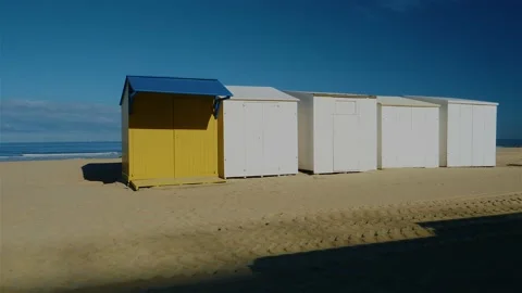 Beach cabins standing next to each other on beach with ocean in the background Видео 220038690
