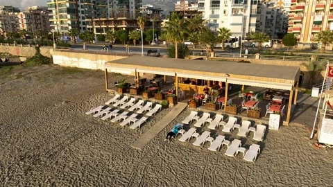 Beach cafe with empty deck chairs aerial view 4 K Stock Footage 236683716