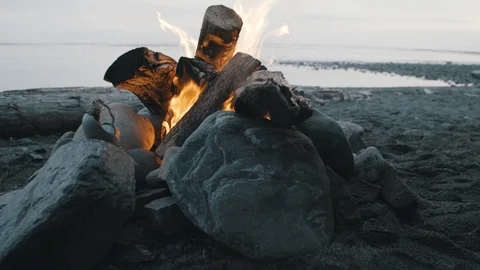 Beach camp fire in fire pit on pacific northwest beach Stock Footage 96081641