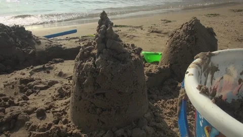 Beach castle pointy sharp sand bucket children kids water sunlight Stock Footage 346609173