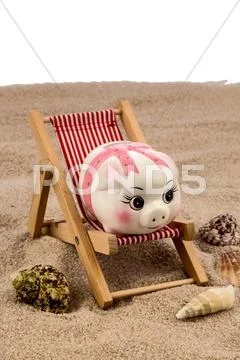 Beach chair with piggy bank Stock Photos