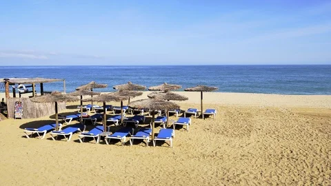 Beach chairs on the white sand beach with blue sky and sun Stock Footage 107776039