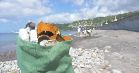 Beach clean up, group picking up trash in eco friendly bag. Stock Footage 106157760
