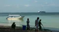 Beach cleaners, boat and cruiseship at Bali beach HD Footage