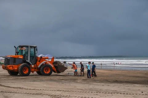 Beach Cleanup with Orange Wheel Loader in Bali Indonesia Foto stock