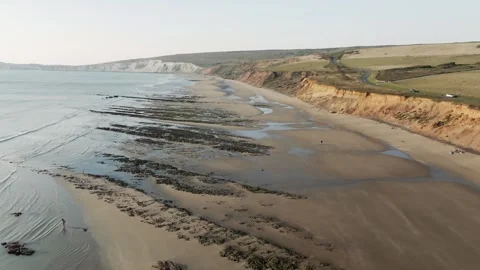 A beach with a cliff in the background Video stock 297951115