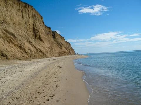 A beach with a cliff in the background.  Stock Photos