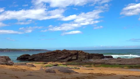 Beach with cliffs and sea waves on a sunny day Stock Footage 131521343