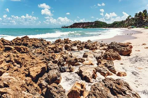 Beach of cliffs and wild blue sea. Stock Photos