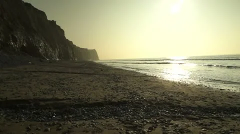 Beach with cliffs at sunset Stock Footage 10844048