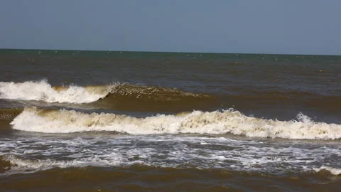 A Beach With A Cloudy Sky And A Cloudy Background. The Waves Of The Sea Wash The Stock Footage 169868856