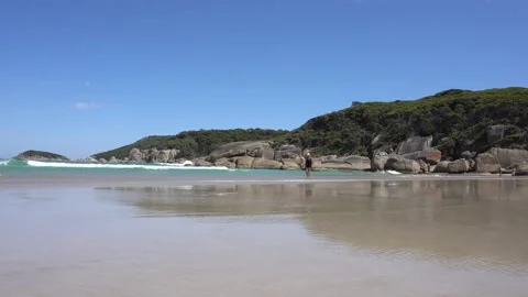 Beach Coastal View Shoreline Waves Coming into Sand as Woman Walking On Beach Stock Footage 237461501