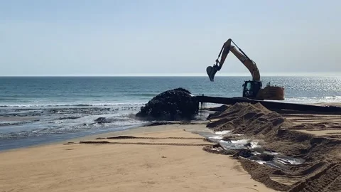 Beach Construction Site with Heavy Machinery and Polluted Water Discharge 動画素材 343874617