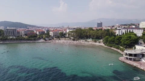 Beach in Croatian city of Split full of unrecognisable people swimming, Stock Footage 253845054