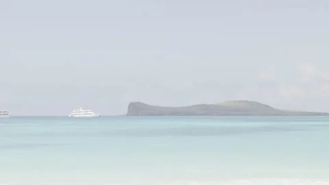 From a beach a cruise can be seen anchored near a paradisiac island of the Vídeo Stock 142010643