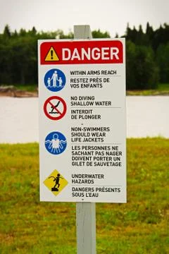 A beach danger sign with rules in both english and french Stock Photos