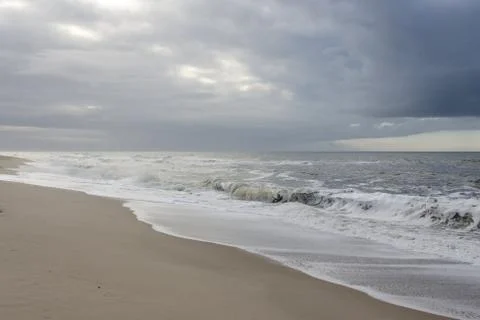 Beach with dark rain clouds Stock Photos