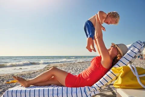 Beach days are the best days. a single mother spending the day at the beach with Stock Photos