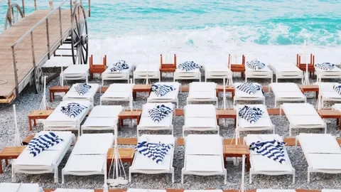 Beach deck chair on a sandy beach by the turquoise sea. Panoramic lounger with Stock Footage 217443003