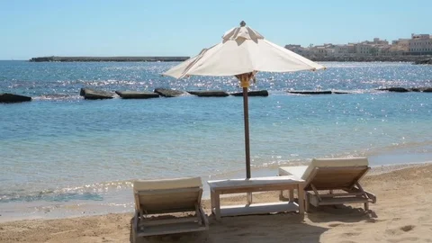 Beach with deck chairs and umbrellas in the Plemmirio nature reserve in Syracuse Video stock 126595044