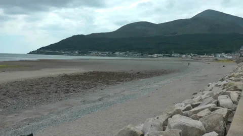 Beach in distance couple walk on empty sands, Newcastle, Northern Ireland Stock Footage 38912762