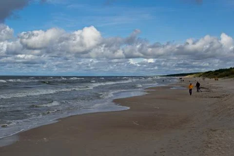 Beach during the day. Clouds and sea waves. Stock Photos