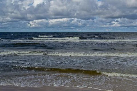 Beach during the day. Clouds and sea waves. Stock Photos