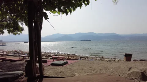 The beach in Eilat with a view of the Mountains of Jordan Stock Footage 195989378