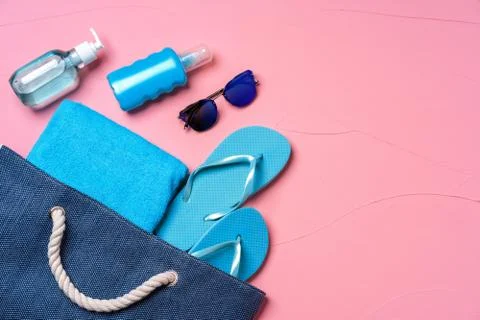 Beach essentials and blue beach bag on pink background Stock Photos
