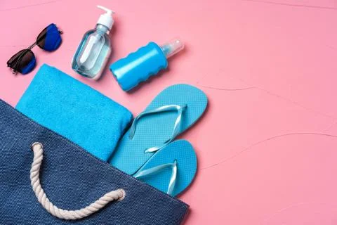 Beach essentials and blue beach bag on pink background Foto stock
