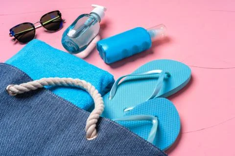 Beach essentials and blue beach bag on pink background Foto stock