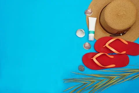 Beach Essentials on blue Background Featuring Hat and Sandals Stock Photos