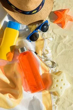 Beach Essentials with Hat, Sunglasses, Sunscreen, Kid Mold and Water Bottle.. Stock Photos