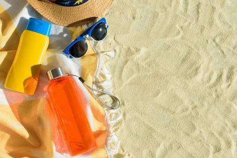Beach Essentials with Hat, Sunglasses, Sunscreen, Kid Mold and Water Bottle.. Stock Photos