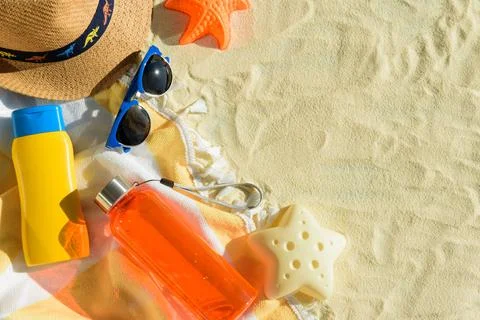 Beach Essentials with Hat, Sunglasses, Sunscreen, Kid Mold and Water Bottle.. Stock Photos