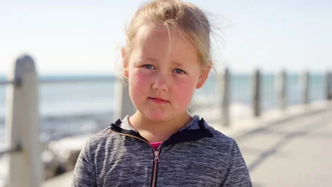 Beach, face and miserable with girl kid outdoor for holiday, travel or vacation 動画素材 331337803