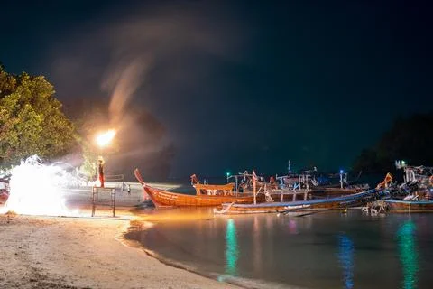 Beach Fire Performer Beside Long-Tail Boats Stock Photos