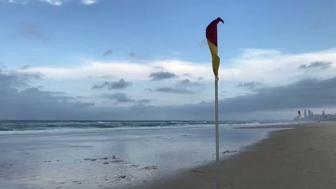 Beach flag getting blown on stormy beach Stock Footage 81339399