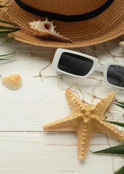 Beach flat lay accessories. Sun hat, palm branch, sunscreen bottle and seashe Stock Photos