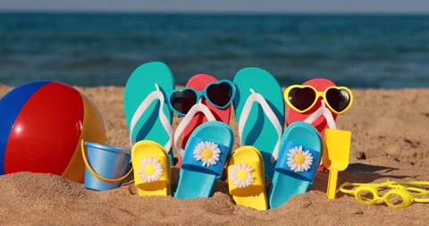 Beach flip-flops on yellow sand against blue sea. Slow motion 스톡 동영상 234815982