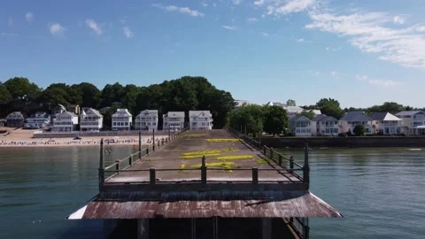 Beach front homes with old pier and lake Stock Footage 220899823