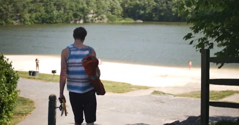Beach Fun at Lake Young Man with Fishing Pole Walking to Water, 4K Stock Footage 64332036