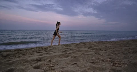 On the beach good looking lady running concentrated through the sea side in the Stock Footage 115204897
