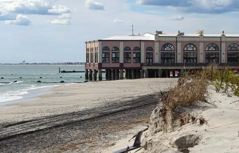 Beach that has been severely eroded with a long enclosed pier jetting out i.. Stock Photos