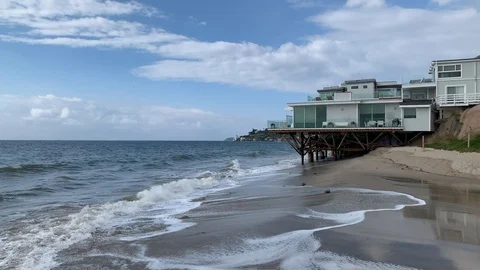 Beach House overlooking waves and beach Stock Footage 125572327