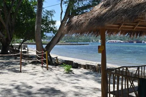 Beach with huts and trees in the background Stock Photos