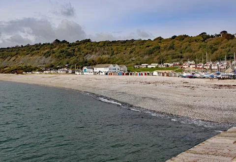 Beach huts on the shingle beach viewed from the Cobb at Lyme Regis, Dorset, E Stock-Fotos