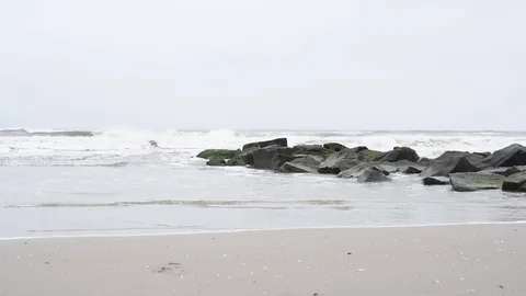 Beach jetty with waves overcast Stock Footage 75763733