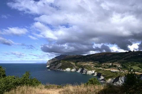 Beach landscape with cliffs on a cloudy day Stock Photos