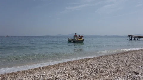 Beach landscape with moored small traditional fishing boat Ionian Sea Corfu Stock Footage 123969293